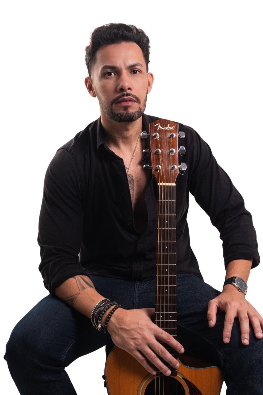 Ricky Moreira segurando o violão na vertical
