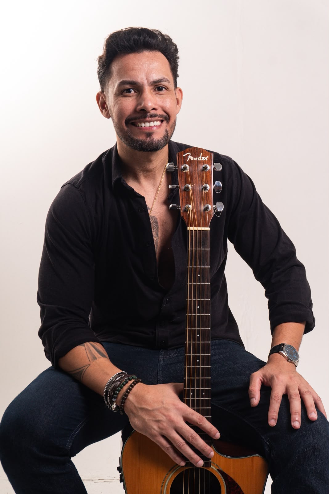 Ricky Moreira sentado com violão